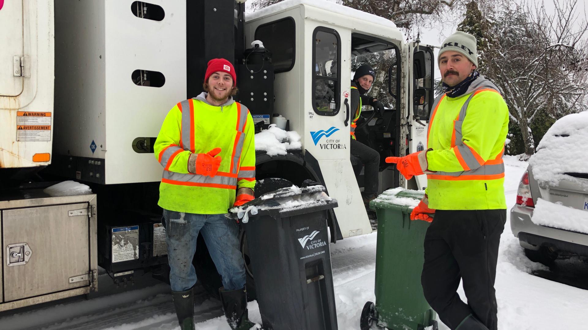 City workers collecting curbside garbage in the snow