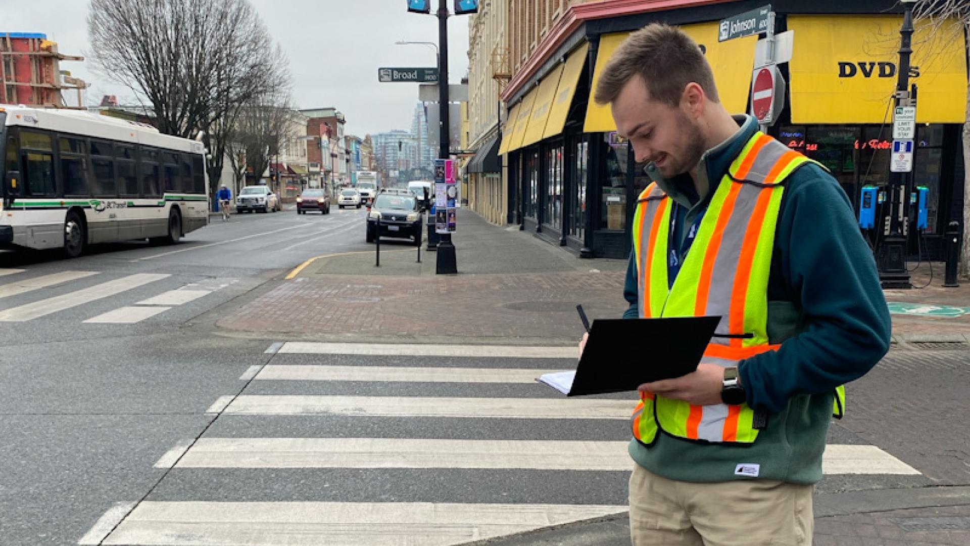 city worker in a visibility vest on a street corner