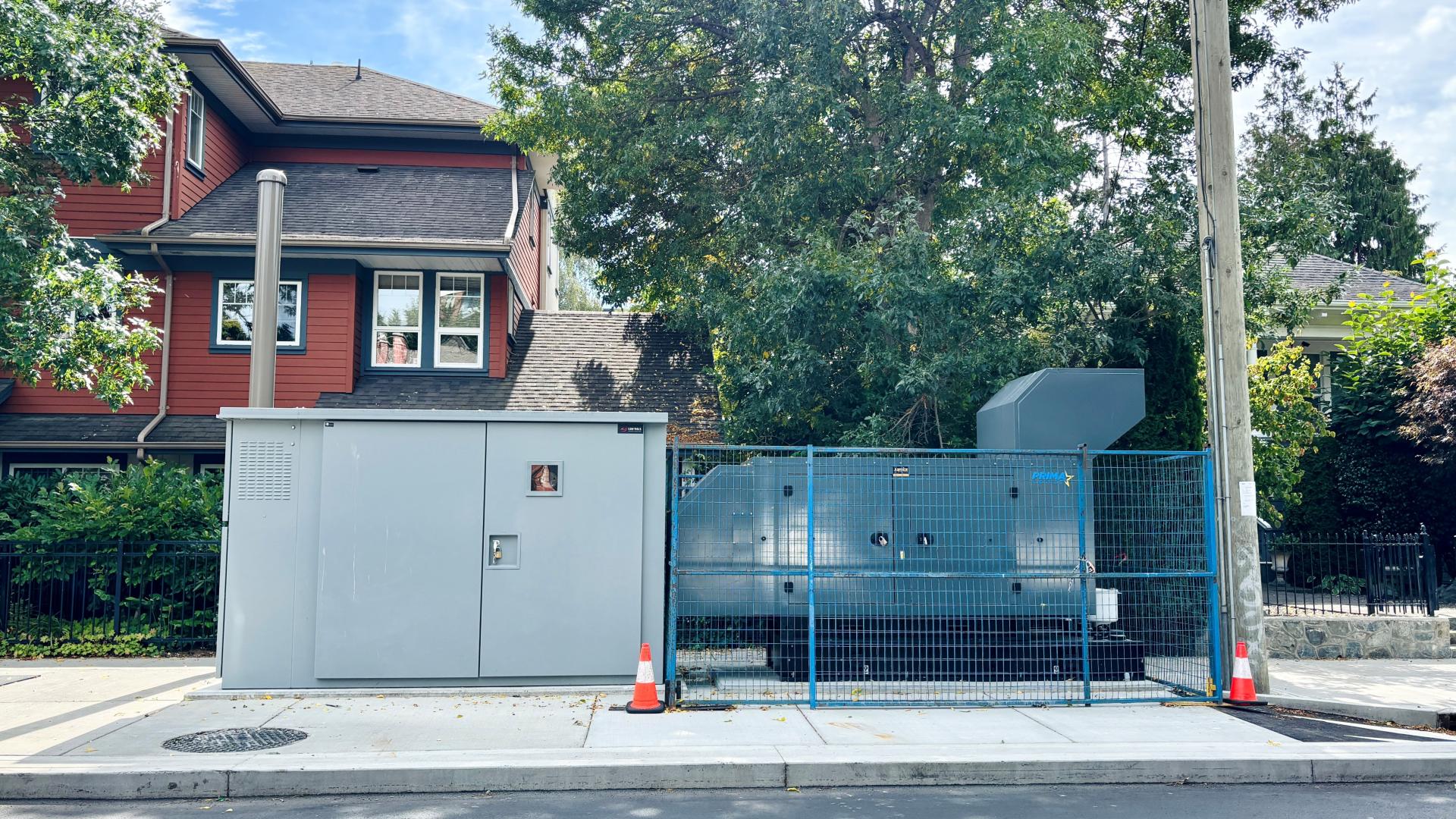 The lift station is made up of two grey, steel boxes, visible next to the sidewalk on Superior Street. at
