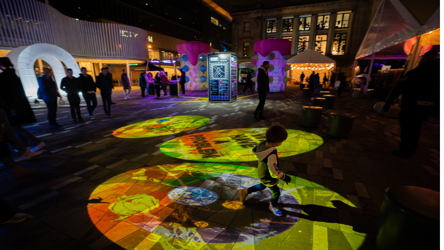 Night image of an artwork projection on a street during a festival